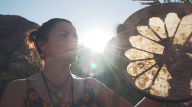 Güneş ışığında tef çalan Kafkasyalı genç bir kadın..