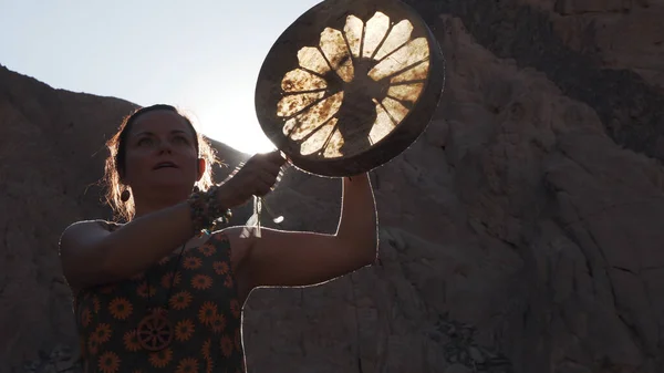 Güneş ışığında tef çalan Kafkasyalı genç bir kadın..