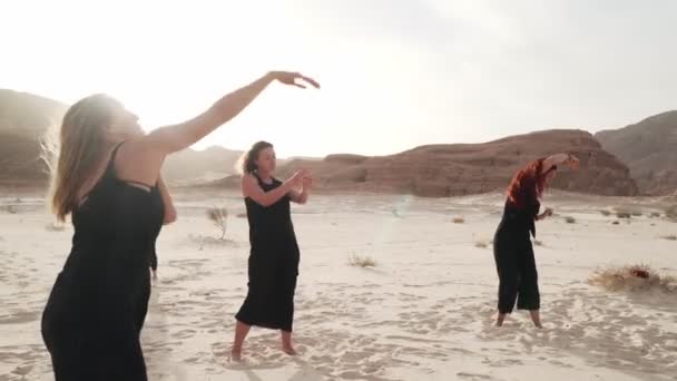 Women practice ecstatic dance in desert at sunrise — Stock Video