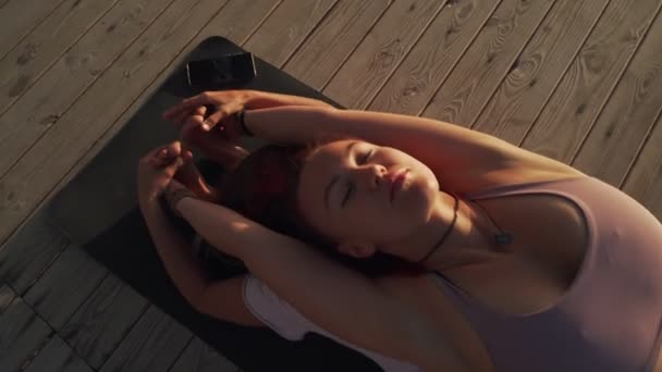 Vue du dessus deux filles pratiquent assis avant et arrière plie posture de yoga au coucher du soleil — Video