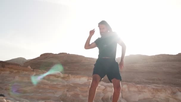 长胡子的男人在阳光下欢快而缓慢地在沙漠中跳舞 — 图库视频影像