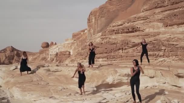 Gruppo di donne in abito nero pratica danza estatica nel canyon del deserto — Video Stock