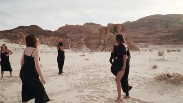 Mujeres libres en ropa negra practican danza extática en el clima ventoso en el desierto — Vídeos de Stock