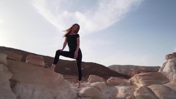 Страстная женщина практикует экстатический танец в пустыне при солнечном свете быстрой замедленной съемки — стоковое видео