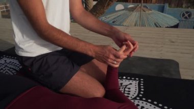 Masör, genç bir kızın ellerine Tayland yogası masajı yapıyor.