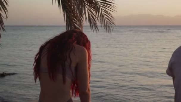 Bakifrån av kvinnor som stretchar yoga vid havet vid soluppgången — Stockvideo