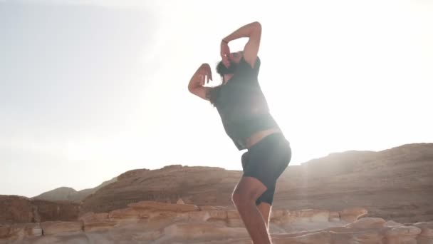 Homem barbudo praticar dança extática no deserto em sol movimento lento rápido — Vídeo de Stock