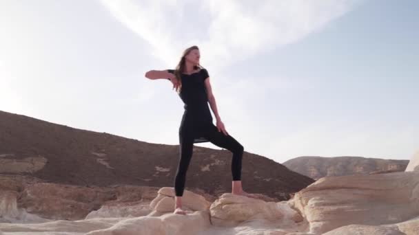 Wanita pirang berlatih tarian gembira di padang pasir dalam gerakan lambat sinar matahari — Stok Video