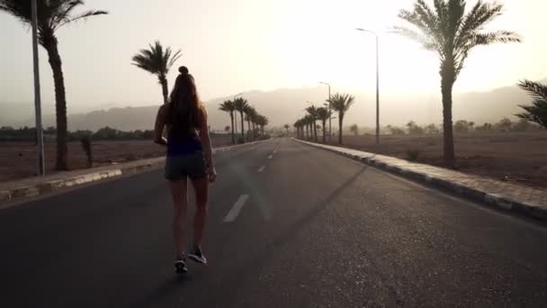 Giovane ragazza caucasica bruna che fa jogging sull'autostrada tropicale all'alba — Video Stock