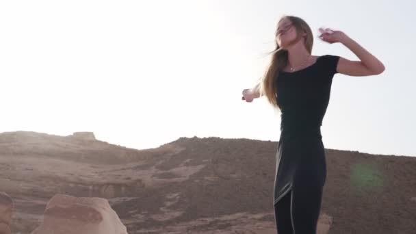 情熱的なブロンドの女性は、太陽の下で砂漠で恍惚ダンスを練習 — ストック動画