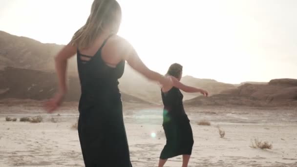 Duas mulheres dançando dança extática no deserto ao sol — Vídeo de Stock