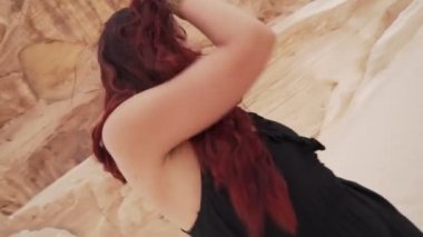 Kızıl saçlı kız çölde coşkulu dans alıştırması yapıyor. Dinamik aktif kamera hareketi