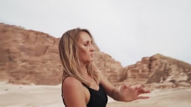 Donna bionda pratica danza estatica nel deserto. Movimento dinamico della telecamera attiva — Video Stock