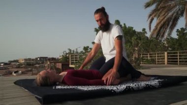 Masör iyileşme ve iyileşme için kadınlara Tayland yogası masajı yapıyor.