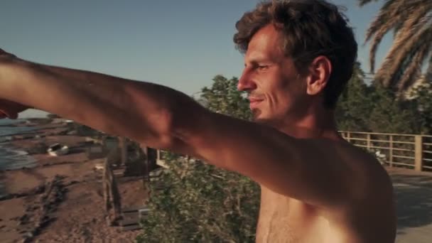 Hombre caucásico guapo practicando yoga a la orilla del mar al amanecer — Vídeo de stock