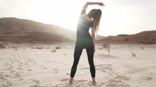 Nő gyakorolni eksztatikus tánc homokos sivatagban napsütésben gyors lassított felvétel — Stock videók