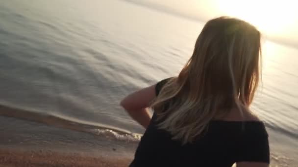 Blondýnka cvičí extatický tanec u moře. Dynamický aktivní pohyb fotoaparátu — Stock video