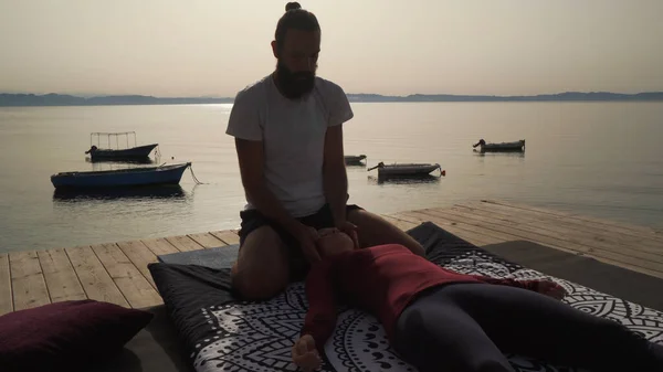 Genç bir kız için geleneksel Tayland yoga masajında sen hatlarıyla çalışan bir masör..