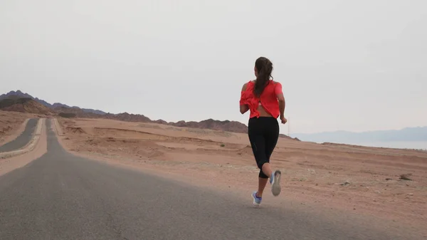 Esmer beyaz kız deniz kıyısında çölde koşuyor..