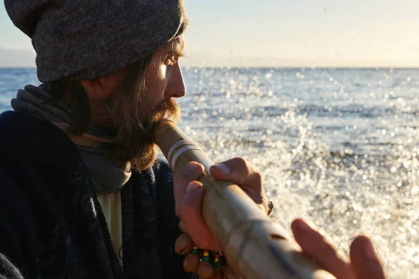 Güneş doğarken Bansuri geleneksel Hint enstrümanını çalan adamı kapatın..