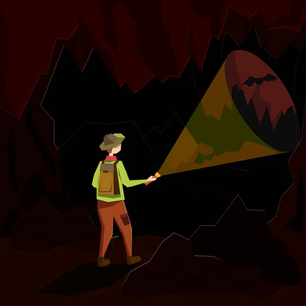 Un giovane uomo si trova in una caverna buia e illumina il suo cammino con una lanterna. Illustrazione in stile piatto . — Vettoriale Stock