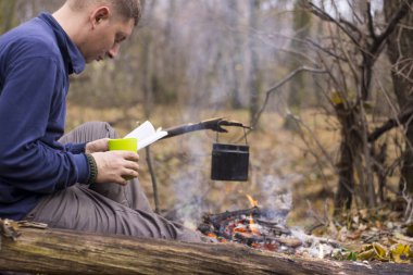 Bir kitap okuma ve sessiz bir sonbahar ormanda çay içme Turizm
