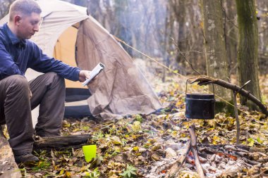 Bir kitap okuma ve sessiz bir sonbahar ormanda çay içme Turizm