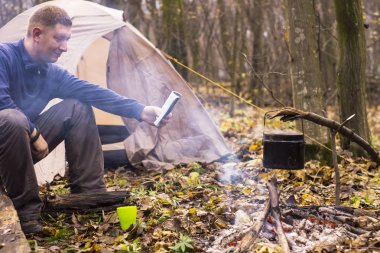Bir kitap okuma ve sessiz bir sonbahar ormanda çay içme Turizm