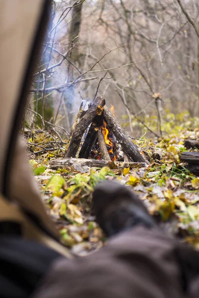 Turisztikai sátorban feküdt, és nézte a tüzet, a hegyi erdő — Stock Fotó