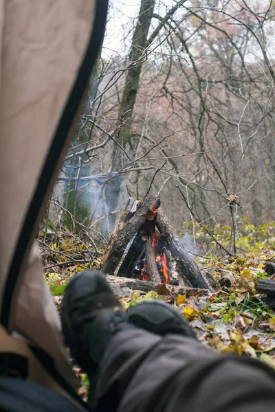 Turistické ležel ve stanu a při pohledu na oheň v horském lese — Stock fotografie