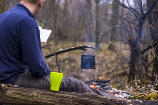 Tourist liest ein Buch und trinkt Tee in einem ruhigen Herbstwald — Stockfoto