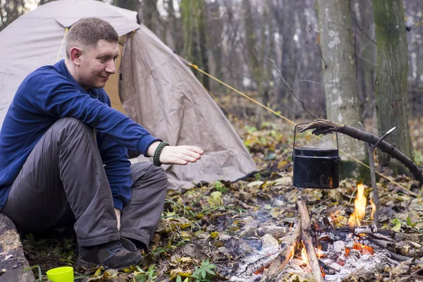 Reizen rond het kampvuur met een tent, het drinken van thee — Stockfoto