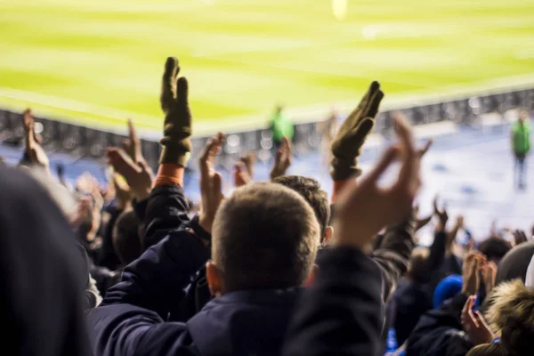 Silhuetas e mãos de torcedores em um estádio de futebol — Fotografia de Stock