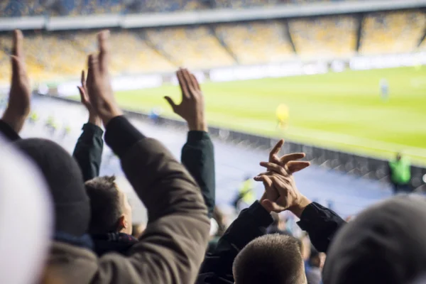 Silhuetas e mãos de torcedores em um estádio de futebol — Fotografia de Stock