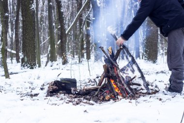 adam ellerini ormanda kamp ateşi etrafında ısınma