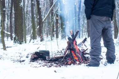 adam ellerini ormanda kamp ateşi etrafında ısınma