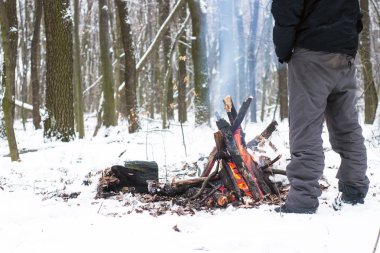 adam ellerini ormanda kamp ateşi etrafında ısınma