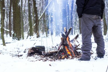 adam ellerini ormanda kamp ateşi etrafında ısınma