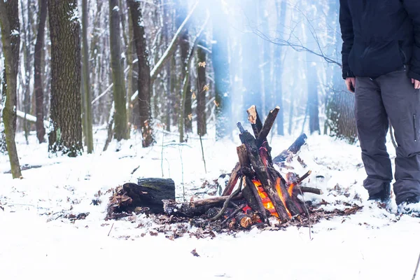 森の中のキャンプファイヤーの周りに彼の手を地球温暖化男 — ストック写真