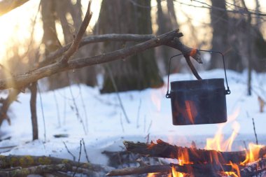 Kış ormanda ateş üzerinde kaynar su bir sürahi sıcak,