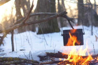 Kış ormanda ateş üzerinde kaynar su bir sürahi sıcak,