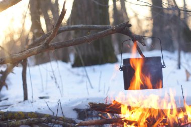 Kış ormanda ateş üzerinde kaynar su bir sürahi sıcak,