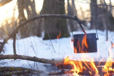 Kış ormanda ateş üzerinde kaynar su bir sürahi sıcak,