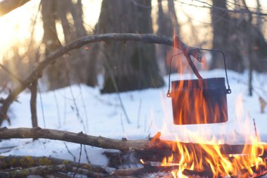 Kış ormanda ateş üzerinde kaynar su bir sürahi sıcak,