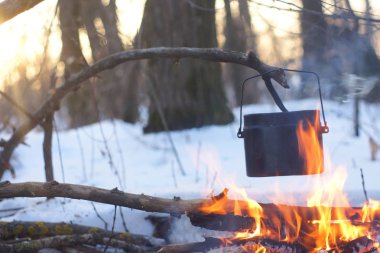 Kış ormanda ateş üzerinde kaynar su bir sürahi sıcak,