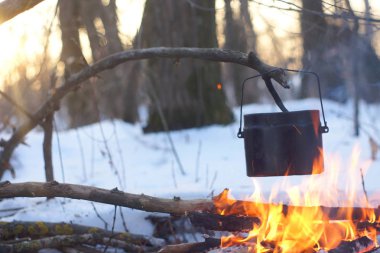 Kış ormanda ateş üzerinde kaynar su bir sürahi sıcak,