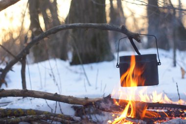 Kış ormanda ateş üzerinde kaynar su bir sürahi sıcak,
