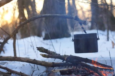 Kış ormanda ateş üzerinde kaynar su bir sürahi sıcak,