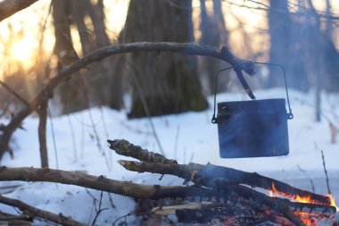 Kış ormanda ateş üzerinde kaynar su bir sürahi sıcak,