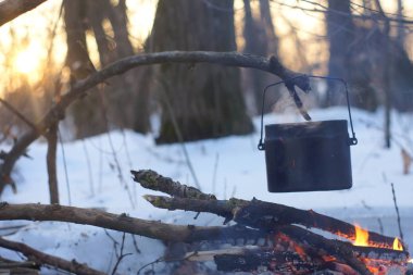 Kış ormanda ateş üzerinde kaynar su bir sürahi sıcak,